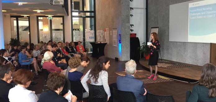 Vrouw geeft presentatie voor volle zaal